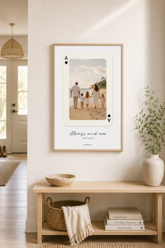 Personoitava 50 × 70 cm pelikorttijuliste omalla perhekuvalla vaalean skandinaavisen kodin eteisessä, kehystettynä vaaleaan puukehykseen.