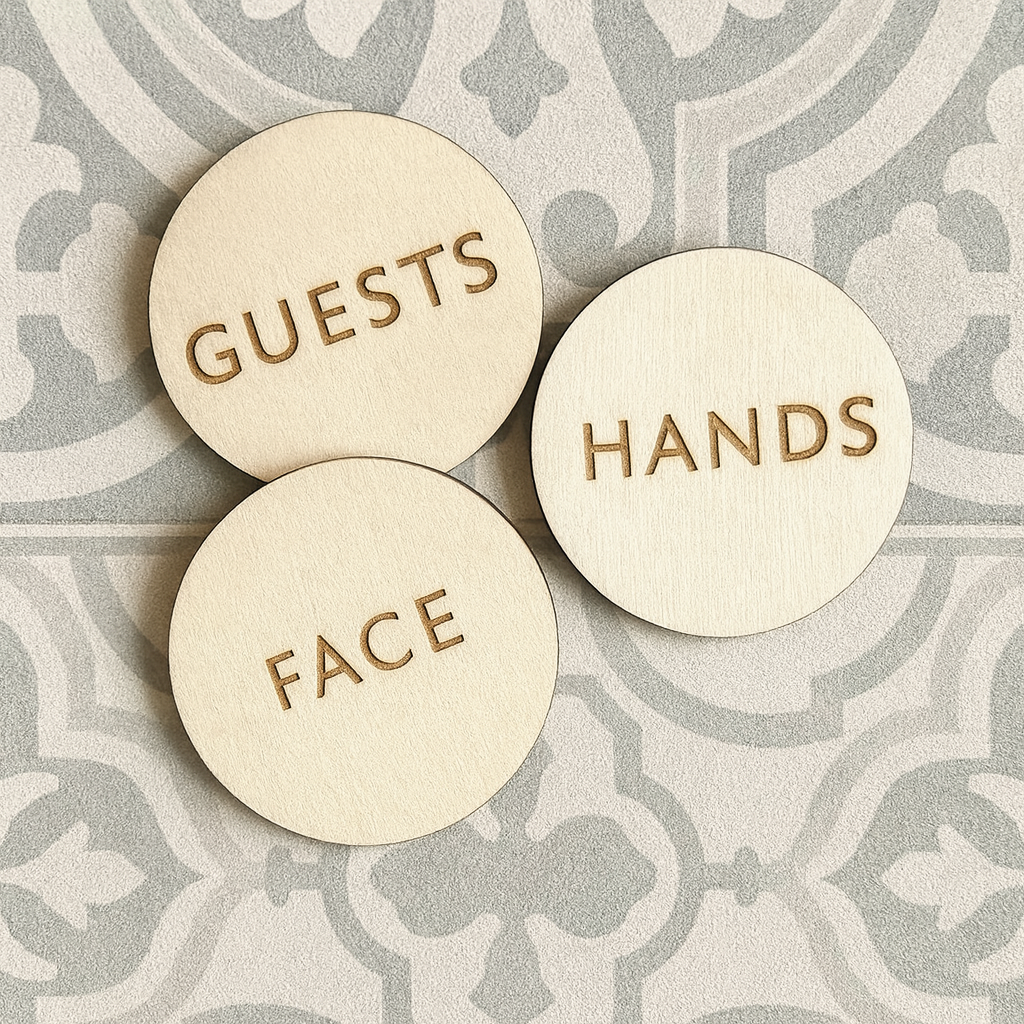 Puiset pyöreät pyyhemerkinnät kaiverretuilla teksteillä Guests, Hands ja Face
